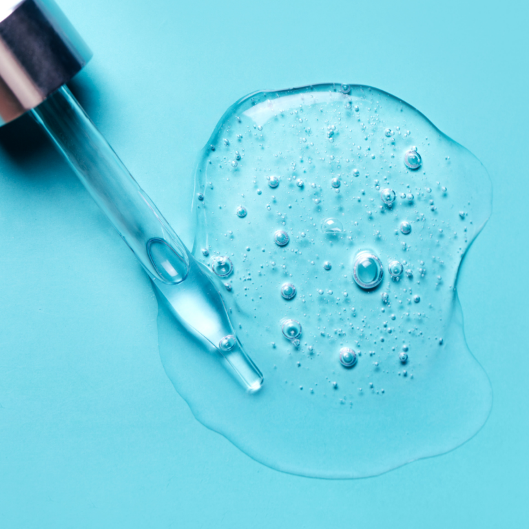 clear hyaluronic serum spilled on a blue background