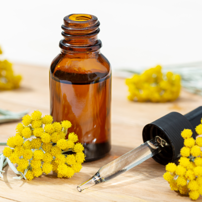 brown apothecary bottle with immortelle flowers
