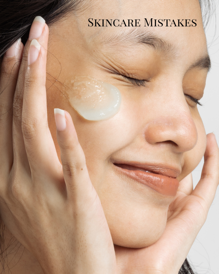 person applying a dollop of skin care to cheek, her face is framed with her hands, eyes closed, smiling