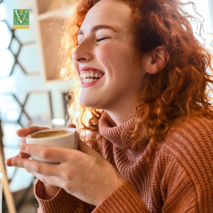 redheaded woman with a big smile and cup of cocoa